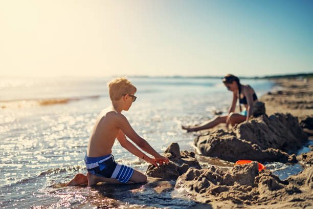 kinder spielen am strand - lifestyles child beach digging stock-fotos und bilder