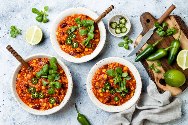 Vegetarian chili con carne with lentils, beans, lime, jalapeno. Mexican traditional dish stock photo
