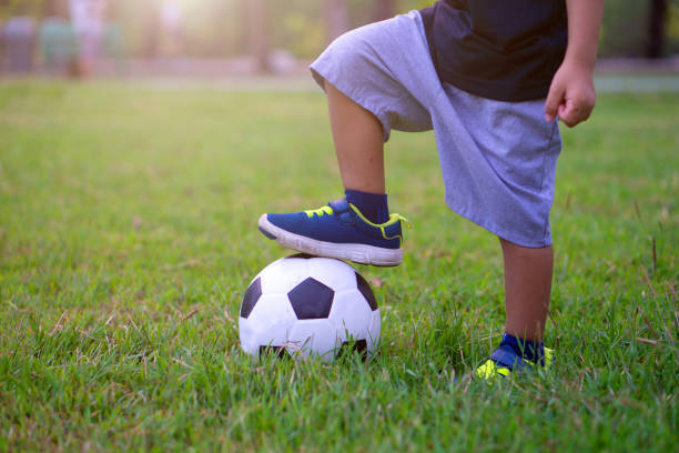 istock Low Section Of Boy Playing Soccer On Field 1129454681
