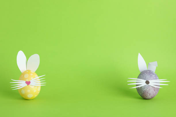 istock Decorated Easter eggs and cute bunny's ears on color background. Space for text 1129454710