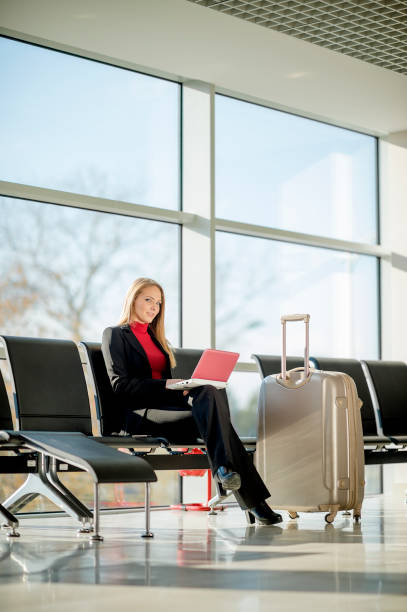 istock Young woman using a laptop in an airport 1129455715