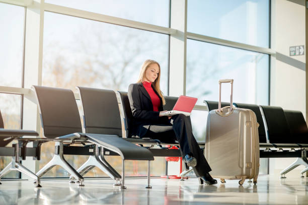 istock Young woman using a laptop in an airport 1129457518