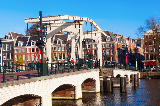 Amsterdam, Netherlands - November 13, 2014: canal with drawbridge in Amsterdam, with unidentified people. Amsterdam is a city with historical canals and more than 3.66 mio visitors a year