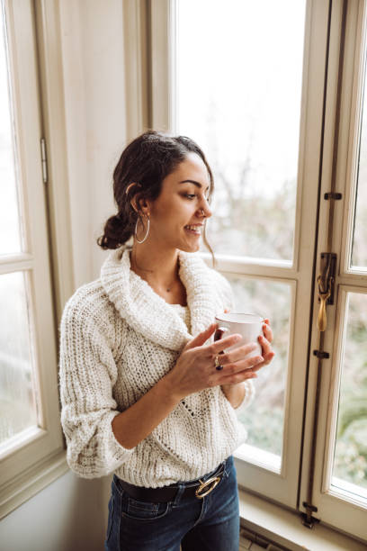 istock pensive woman in front of the window 1129464266