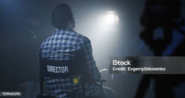 Direktor Sitzt In Seinem Sessel Auf Einem Filmset Stockfoto und mehr Bilder von Regiestuhl - Regiestuhl, Filmset, Anweisungen geben