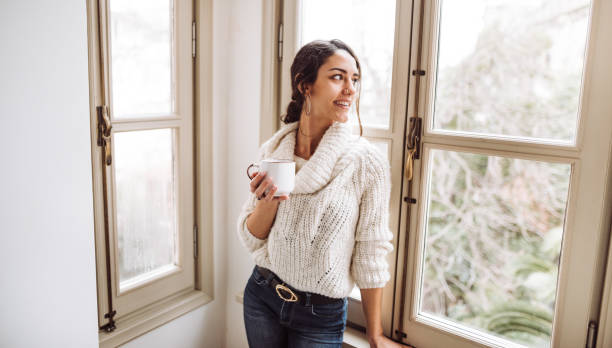 istock happiness woman in front of the window 1129464352