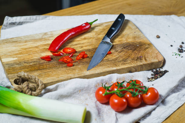 istock The chef cuts chili peppers on a wooden chopping Board. Background kitchen 1129465739