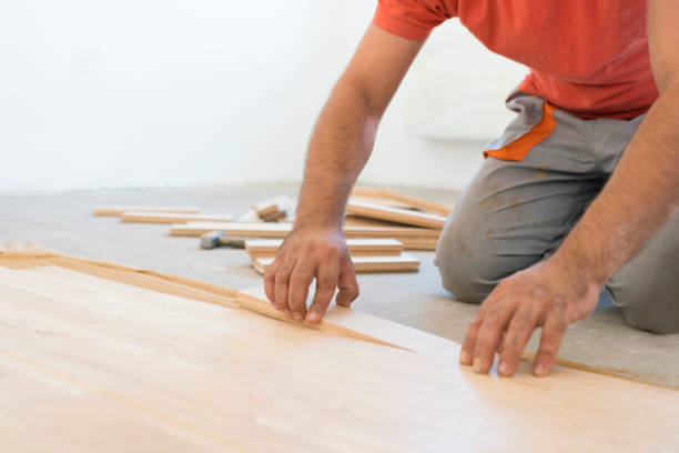 istock Carpenter lining up hardwood parquet planks 1129467224