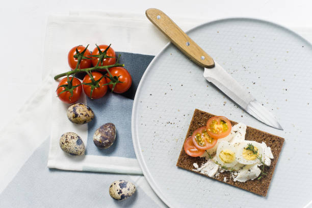 istock Quail egg toast. Ingredients tomatoes, egg, cheese, rye bread. White background, 1129467477
