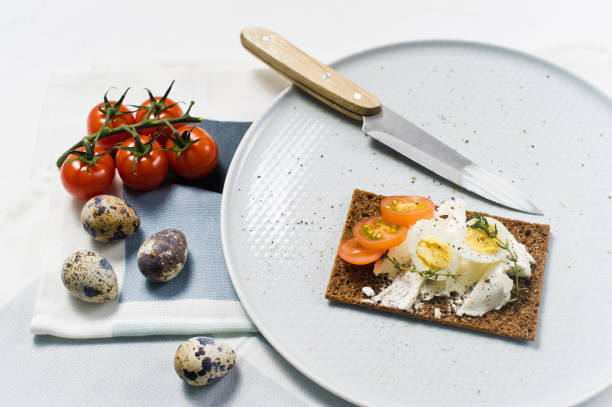 istock Quail egg toast. Ingredients tomatoes, egg, cheese, rye bread. White background 1129467499