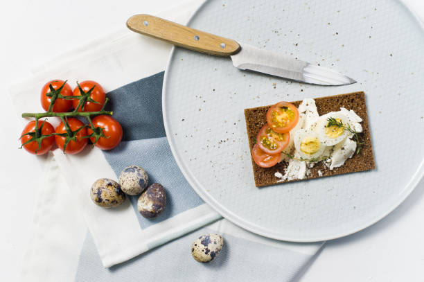 istock Quail egg toast. Ingredients tomatoes, egg, cheese, rye bread. White background, 1129467522