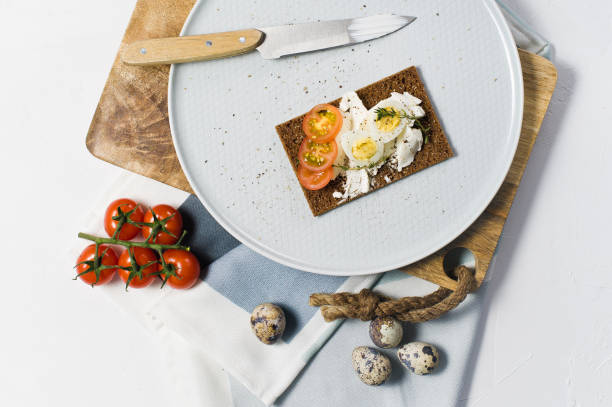 istock Quail egg toast. Ingredients tomatoes, egg, cheese, rye bread. White background 1129467543