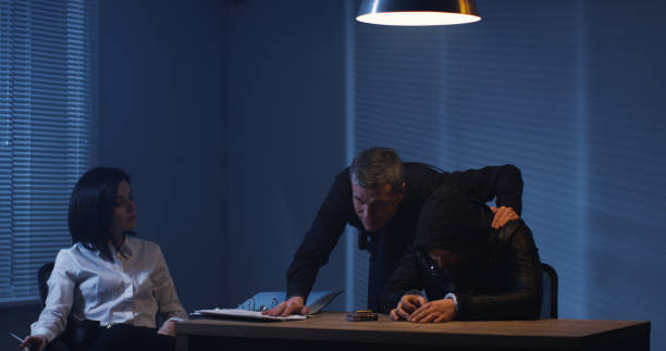 istock Policemen with arrested suspect in interview room 1129468383