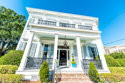 New Orleans, USA - April 23, 2018: Old street historic Garden district in Louisiana famous town city with real estate historic white blue house