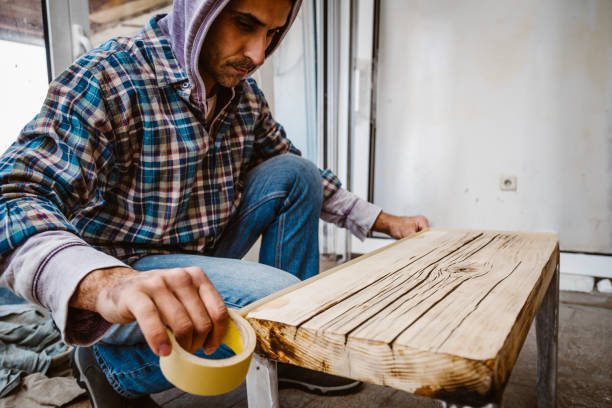 istock Male craftsman makes a wooden table 1129482372