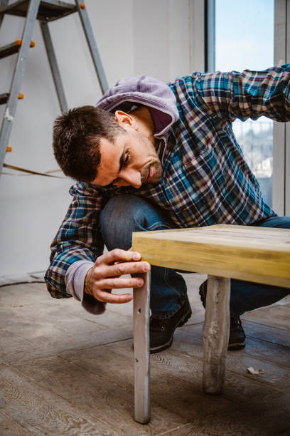 istock Male craftsman makes a wooden table 1129483300