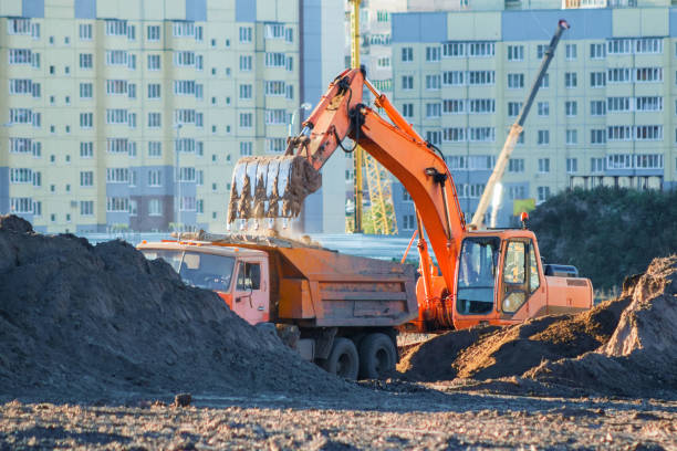 istock Excavator loads the earth into a dump truck. 1129484356