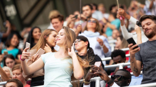 istock Beautiful young woman taking a selfie during concert 1129484489