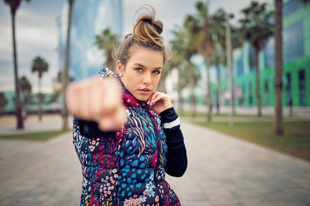 runner girl sta boxe lungo la spiaggia dopo una lunga corsa - jogging autumn young women women foto e immagini stock