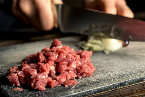 istock female hands cut onions, meat is near 1129485784