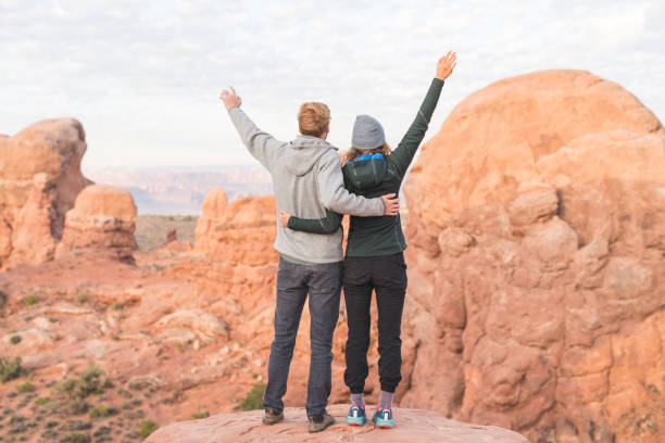 istock Two young hikers enjoy the sunrise in the Utah desert 1129486556