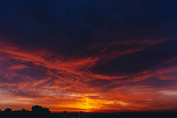 istock Fiery red blood vampire dawn. Amazing warm dramatic fire blue dark cloudy sky. Orange sunlight. Atmospheric background of sunrise in overcast weather. Hard cloudiness. Storm clouds warning. Copy space 1129486640