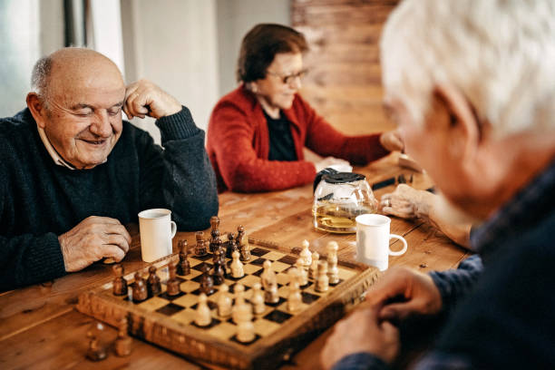 Thinking about next move Senior people having fun in nursing home senior chess stock pictures, royalty-free photos & images