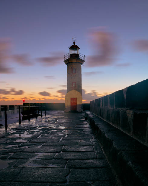 istock Lighthouse on the pier at sunset 1129492163