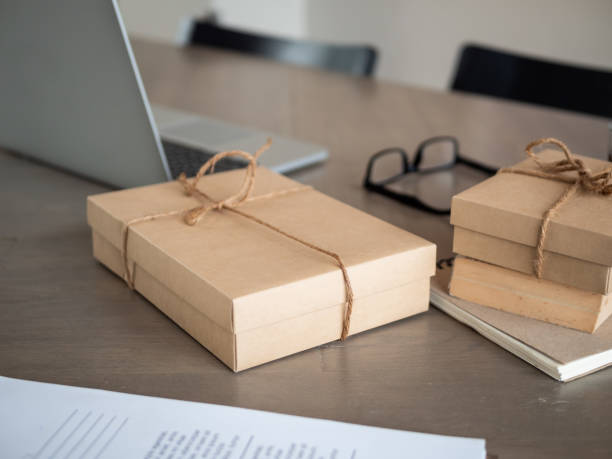 istock Laptop computer and parcel box on wooden table in home. startup small business owner, for online selling.  shipping concept, Family business 1129499883