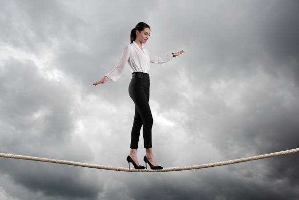 istock Businesswoman walking on a rope 1129502353