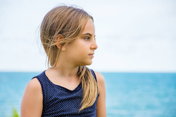 istock Child sitting in front of the sea 1129503427