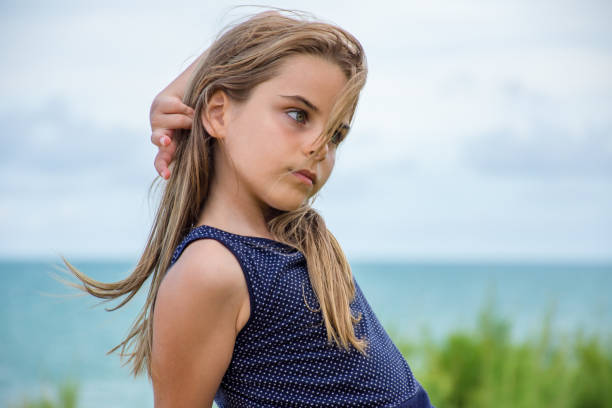 istock Child sitting in front of the sea 1129503762