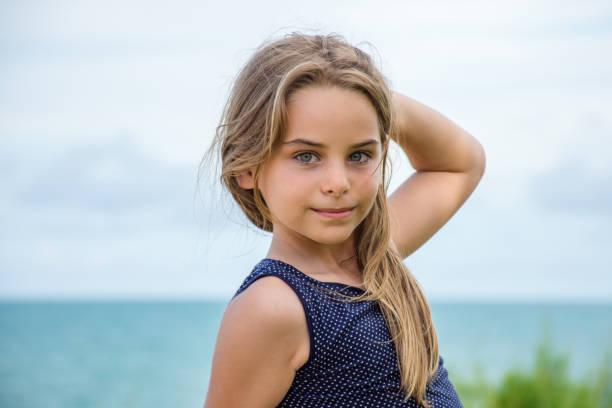 Child sitting in front of the sea on a beautiful summer day