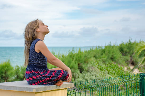 Child sitting in front of the sea on a beautiful summer day
