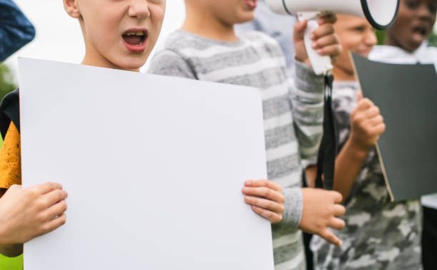 istock Young boy showing a blank paper in a protest 1129512737