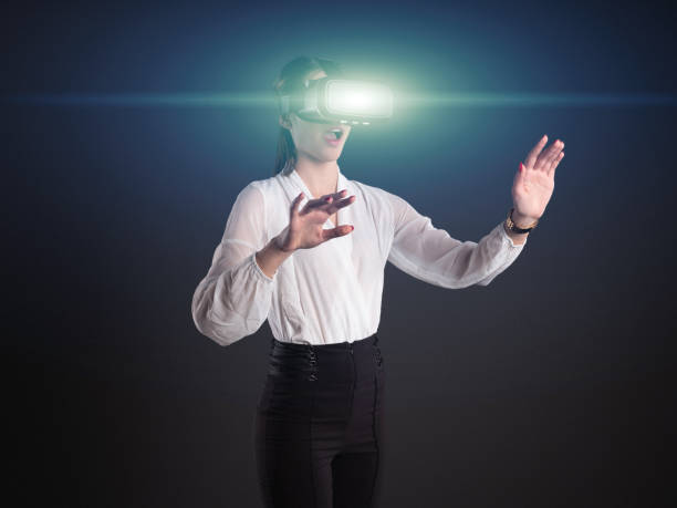 istock Businesswoman with VR goggles with futuristic light effect 1129514234