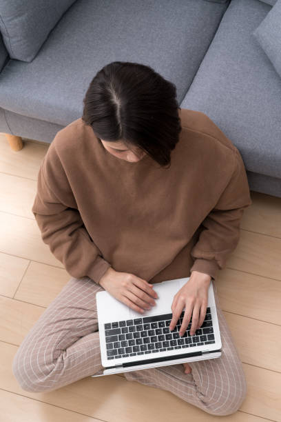 istock asian female sit on sofa 1129515693