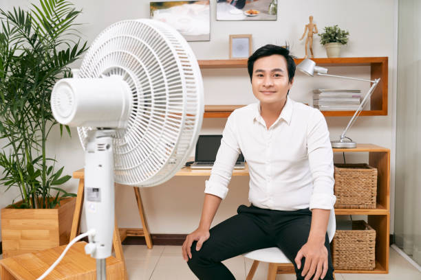 istock Happy man sitting in front of fan 1129523467