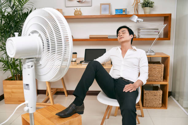 istock Businessman relaxing in front of fan 1129523468
