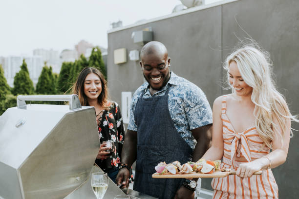 istock Happy friends grilling at a rooftop party 1129529639