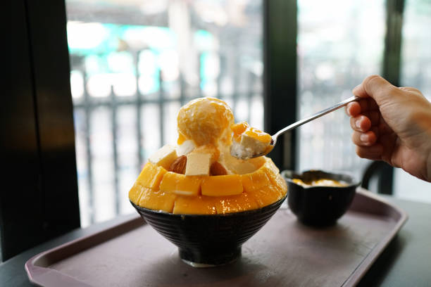 mango cheese bingsu or korean shaved ice dessert, topped with vanilla ice cream. - cheesecake syrup almond cream imagens e fotografias de stock