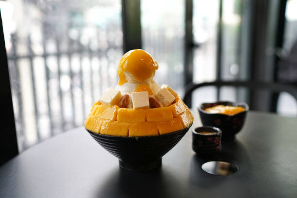 mango cheese bingsu or korean shaved ice dessert, topped with vanilla ice cream. - cheesecake syrup almond cream imagens e fotografias de stock