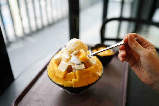 mango cheese bingsu or korean shaved ice dessert, topped with vanilla ice cream. - cheesecake syrup almond cream imagens e fotografias de stock