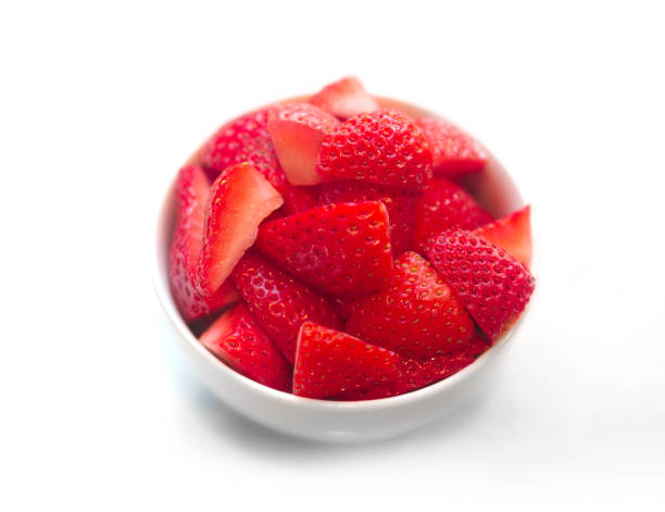 Fresh cut strawberries in white bowl isolated on white background