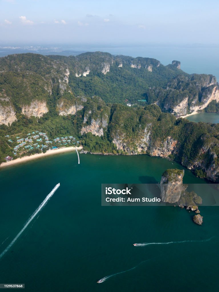 Aerial image of Ao Nang beach in Krabi province, Thailand. Beautiful green limestone rocks, white boats sailing on the sea. Aerial photo of Ao Nang beach in Krabi, Thailand. Thailand landscape with beach, green rocks, sand and boats on the sea. Andaman Sea Stock Photo