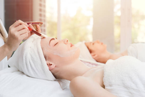 istock women doing face skin spa massage with asian herbal paste. 1129543252