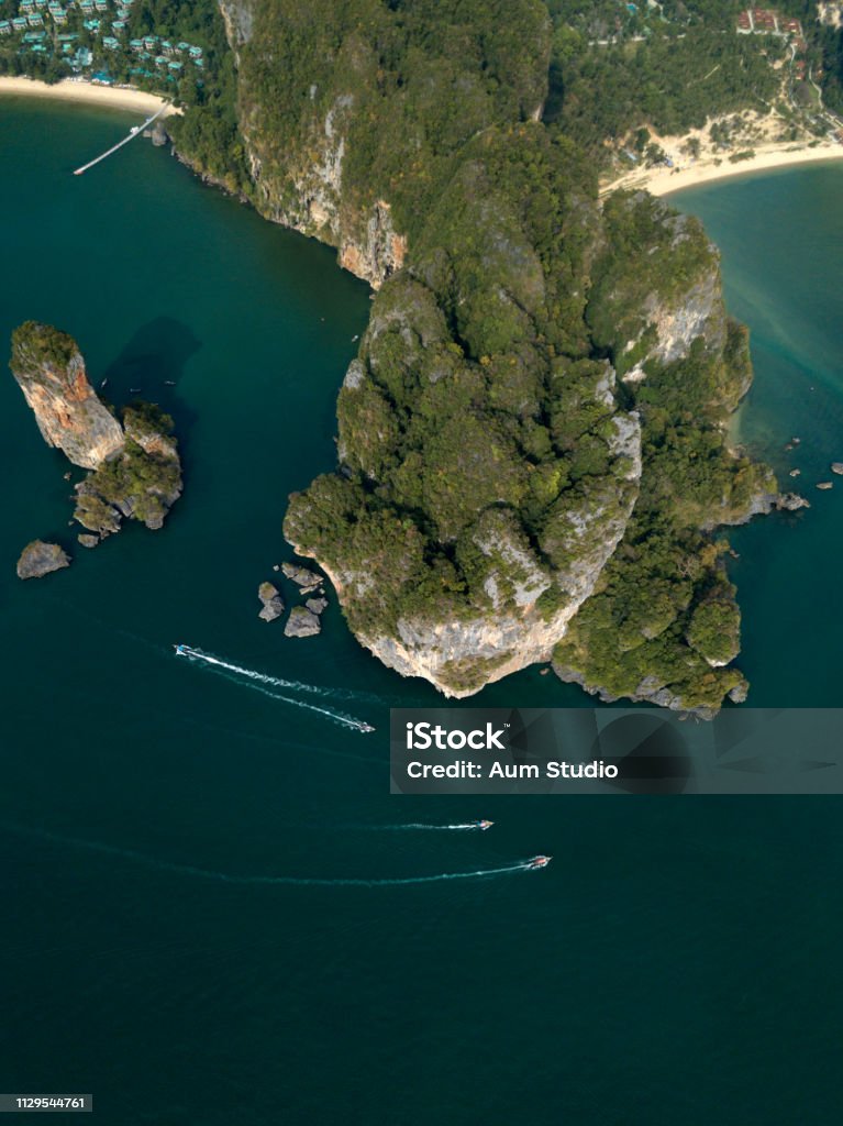 Aerial panoramic photo of Ao Nang beach, Pai Plong beach, Railay beach with limestone green rocks, sand and green colour sea. Krabi, Thailand. Photo from drone of Ao Nang beach, Krabi, Thailand. Boats float around the green rocks. Andaman Sea Stock Photo