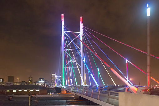 Nelson Mandela Bridge at night. The 284 metre long Nelson Mandela Bridge, starts at the end of Jan Smuts Avenue and linking Braamfontein to the Cultural precinct in Newtown.