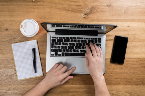 istock Working on laptop. man working on computer. Top view of person in modern office interior. 1129549973
