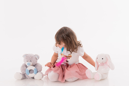 Cute little girl sitting her teddy bear over white background